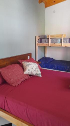 a bedroom with a bed with a red bedspread at Puesta del Sol Apart in Puerto Iguazú