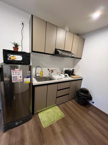 Una pequeña cocina con fregadero y refrigerador. en CASA JBL Megatower 4, en Baguio