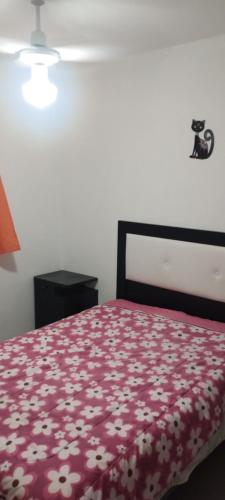 a bedroom with a bed with a red blanket with flowers at La Candelaria in La Punta