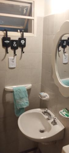 a bathroom with a white sink and a mirror at La Candelaria in La Punta