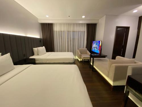 een hotelkamer met 2 bedden en een flatscreen-tv bij The Forest Lodge at Camp John Hay privately owned unit with parking 535 in Baguio