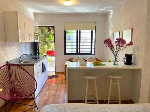 a kitchen with a counter and a kitchen island with stools at Beguest Centro Concerts & Events in Mexico City