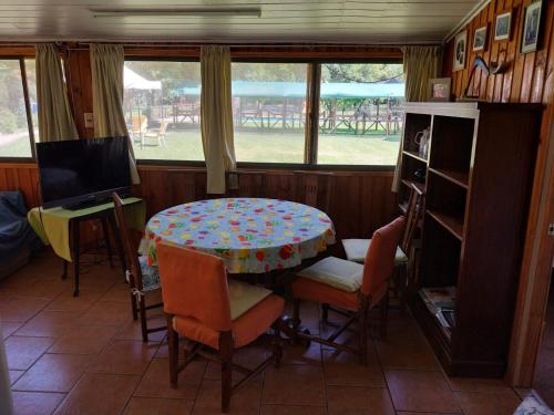 a dining room with a table and chairs and a window at Paine - Hermosa Parcela de Agrado in Santiago