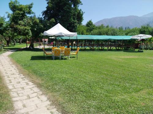 a group of tables and chairs in a park at Paine - Hermosa Parcela de Agrado in Santiago