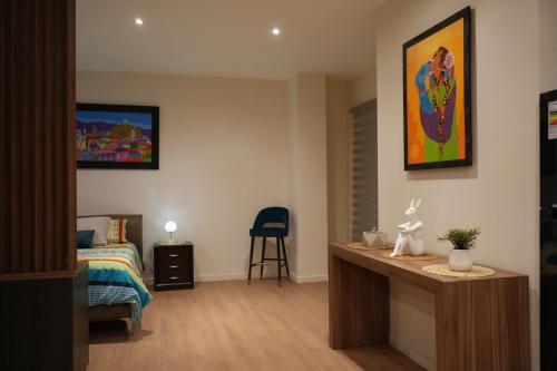 a bedroom with a bed and a desk in a room at Monoambiente de Lujo Cores in Cochabamba