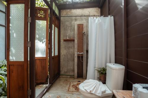 a bathroom with a shower and a toilet in it at Proud Phu Fah Maerim Resort in Mae Rim