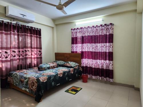 ein Schlafzimmer mit einem Bett und Vorhängen in einem Zimmer in der Unterkunft Aaira guest house in Dhaka