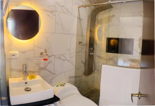y baño blanco con lavabo y ducha. en Hotel Campestre Nogal de Cafetal, en Quimbaya