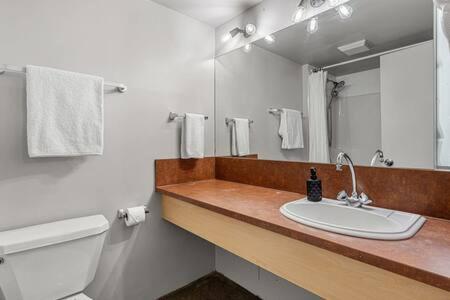 a bathroom with a white toilet and a sink at The Pastel I Closest Available Airbnb To Stampede in Calgary