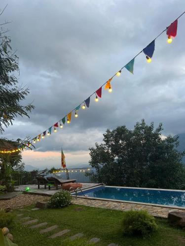 a string of flags hanging over a swimming pool at Awesome Place in Ella