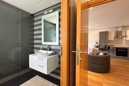 a bathroom with a sink and a mirror at Marvelous Ocean View Suite Marina - By AppartAli in Casablanca