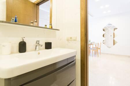 a white bathroom with a sink and a shower at Triangle D Or Bourgogne - By AppartAli in Casablanca