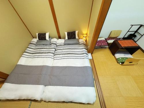 Łóżko lub łóżka w pokoju w obiekcie 山雲居