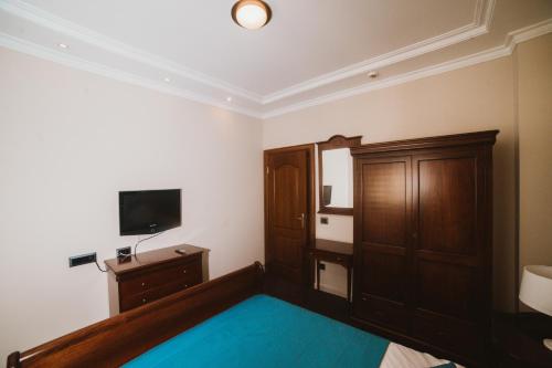 a bedroom with a bed and a flat screen tv at Hotel Astoria in Tivat