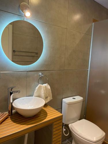 ein Badezimmer mit einem Waschbecken, einem WC und einem Spiegel in der Unterkunft Martita House in Clorinda