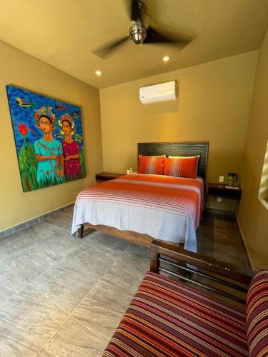 a bedroom with a bed and a painting on the wall at Quinta Viajero in Zipolite