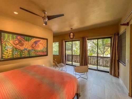 a bedroom with a bed and a balcony with windows at Quinta Viajero in Zipolite