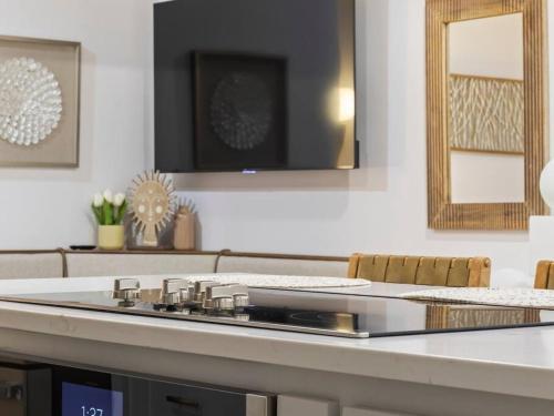a kitchen with a counter top with chairs and a mirror at Hook St Art Pad: Just 5 Mins to Downtown Vibes! in Bentonville