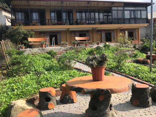 a garden with a table and chairs and a building at Sau Meo Mountain View in Sa Pa