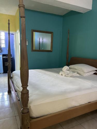a bed in a bedroom with a blue wall at Bay Heights Escape in Gros Islet