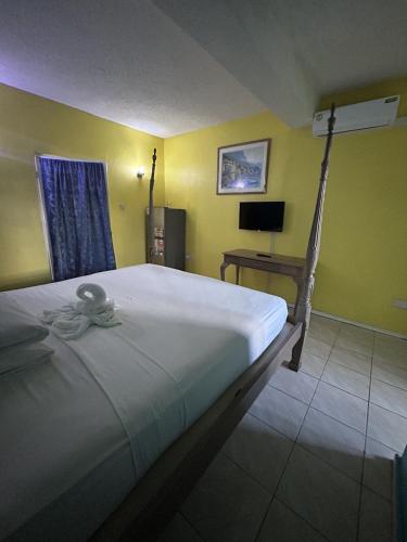 1 dormitorio con 1 cama grande y TV en Bay Heights Escape, en Gros Islet