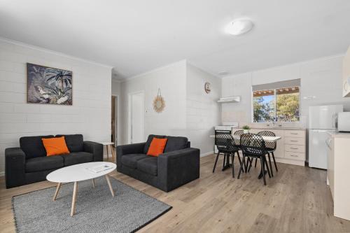 a living room with two couches and a table at Riversands Rest Accommodation Scenic Riverfront Cottages, Paringa in Renmark