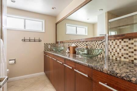 a bathroom with two sinks and two mirrors at Ocean View 3 bedroom Manhattan Beach Parking in Manhattan Beach