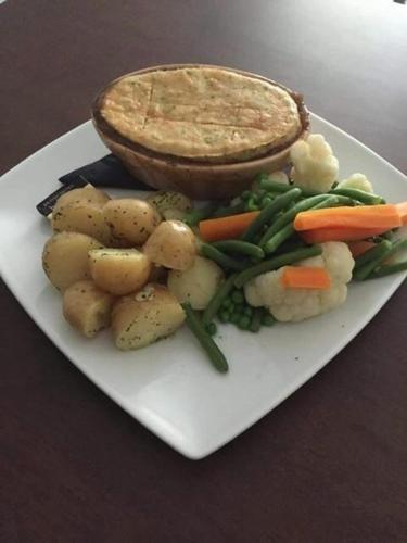 a plate of food with potatoes and vegetables on a table at The Royal George Staithes in Staithes