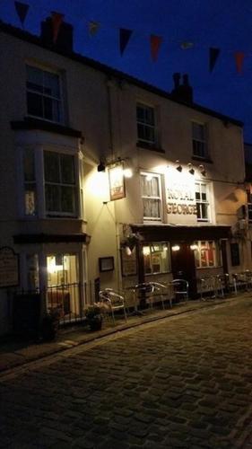 a lit up building on a street at night at The Royal George Staithes in Staithes