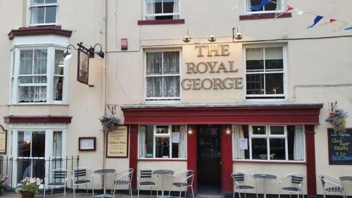 a building with tables and chairs in front of it at The Royal George Staithes in Staithes