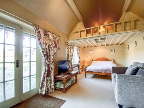 a bedroom with a loft bed and a couch at Oaklands Farm - Cottage 4 in Broughton