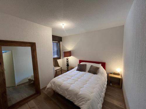 - une chambre avec un lit et un miroir dans l'établissement Appartement Centre Les Gets - Balcon & Proche Remontées - 5/6 Couchages - FR-1-623-175, aux Gets