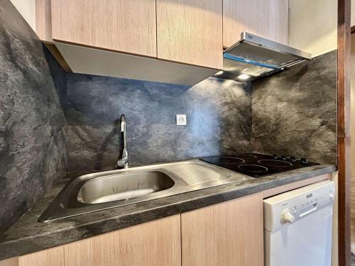 une cuisine avec un évier et une cuisinière dans l'établissement Splendide appartement lumineux 4 pièces 7 couchages avec jardin privé, proche commodités - FR-1-330F-232, au Monêtier-les-Bains