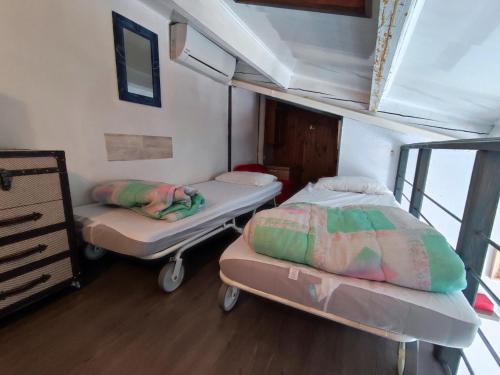 deux lits dans une petite pièce avec une fenêtre dans l'établissement Pavillon Climatisé Près de la Plage avec Terrasse, Parking et Confort Moderne - FR-1-776-7, à Argelès-sur-Mer