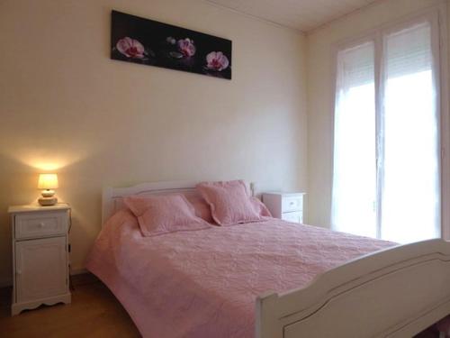 - une chambre avec un lit avec des draps roses et une fenêtre dans l'établissement Villa rénovée 4 pièces, proche plage et commerces, jardin et parking, animaux acceptés - FR-1-776-8, à Argelès-sur-Mer