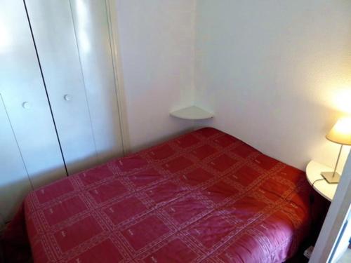 - une petite chambre avec un lit rouge dans l'établissement Appartement Argelès-sur-Mer, 2 pièces, 4 personnes - FR-1-776-18, à Argelès-sur-Mer