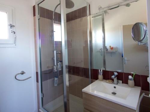 une salle de bain avec un lavabo et une douche avec un miroir dans l'établissement Duplex rénové 6 pers avec piscine, terrasse, parking à 400m de la plage - FR-1-776-17, à Argelès-sur-Mer