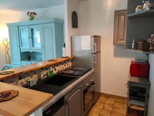 une cuisine avec un évier et un réfrigérateur dans l'établissement Bel appartement 2 chambres à 150m de la plage avec terrasse et wifi gratuit - FR-1-323-453, à Saint-Jean-de-Monts