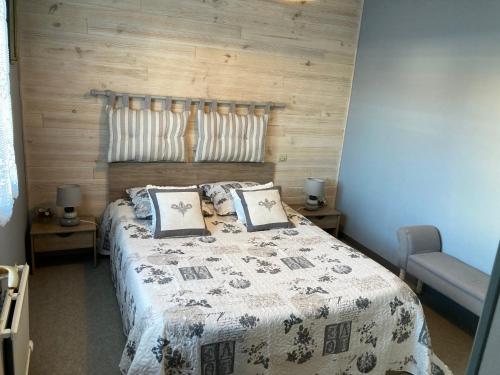 une chambre avec un grand lit avec un mur en bois dans l'établissement Bel appartement 2 chambres à 150m de la plage avec terrasse et wifi gratuit - FR-1-323-453, à Saint-Jean-de-Monts