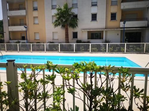 une piscine devant un immeuble dans l'établissement Appartement 4 pers, piscine, terrasse avec BBQ, parking, proche plage – Argelès-sur-Mer - FR-1-776-27, à Argelès-sur-Mer