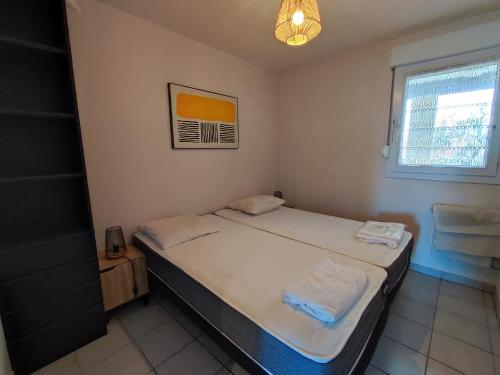 une petite chambre avec un lit et une fenêtre dans l'établissement Appartement 3 pers avec piscine, terrasse et parking privé - FR-1-776-22, à Saint-Cyprien