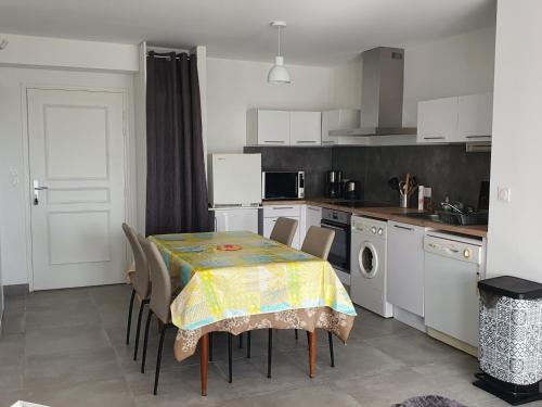 une cuisine avec une table recouverte d'une nappe dans l'établissement Appartement Confort 4 Pers, Climatisé, Terrasse, Parking, Proche Plage - FR-1-776-12, à Argelès-sur-Mer