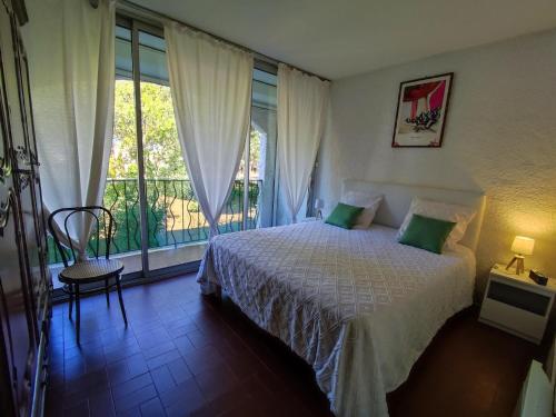 une chambre avec un lit et une grande fenêtre dans l'établissement Appartement Climatisé 4 Pers, Piscine, Tennis, Proche Plage - FR-1-776-45, à Argelès-sur-Mer