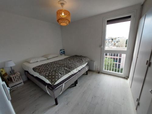 une chambre avec un lit et une grande fenêtre dans l'établissement Appartement avec WIFI, climatisation et parking - 400m de la plage - FR-1-776-15, à Saint-Cyprien