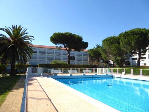 une piscine devant un immeuble dans l'établissement Appartement 2 Pièces à Argelès-sur-Mer, à 300m de la Plage avec Piscine, Tennis et Animaux Acceptés - FR-1-776-48, à Argelès-sur-Mer