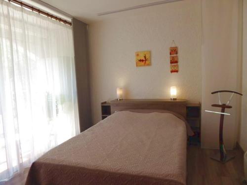 une chambre avec un lit et une grande fenêtre dans l'établissement Appartement 2 Pièces à Argelès-sur-Mer, à 300m de la Plage avec Piscine, Tennis et Animaux Acceptés - FR-1-776-48, à Argelès-sur-Mer