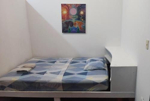 Bett in einem Zimmer mit einem Bild an der Wand in der Unterkunft AYA NI in Pucallpa