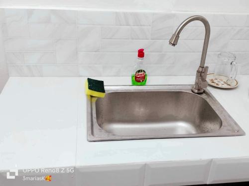 a kitchen sink with a sponge next to it at 3K’s Transient house in Bagac in Malawin