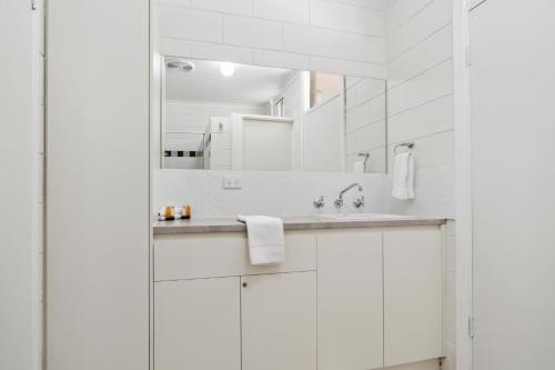 a white bathroom with a sink and a mirror at Riversands Rest Accommodation Paringa - Willow Cottage in Renmark