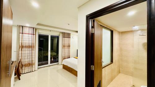 a bedroom with a bed and a window and a door at May Hotel Sonasea Phu Quoc in Phu Quoc